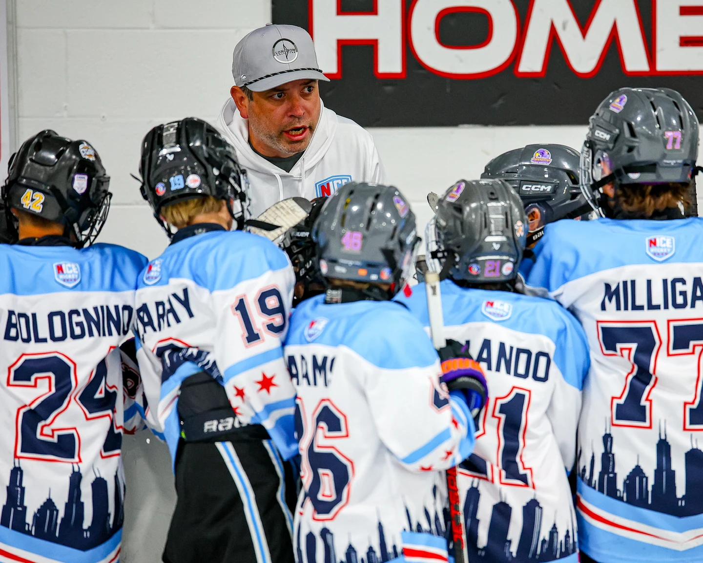 Coach speaking to NICE Hockey players gathered in a team huddle